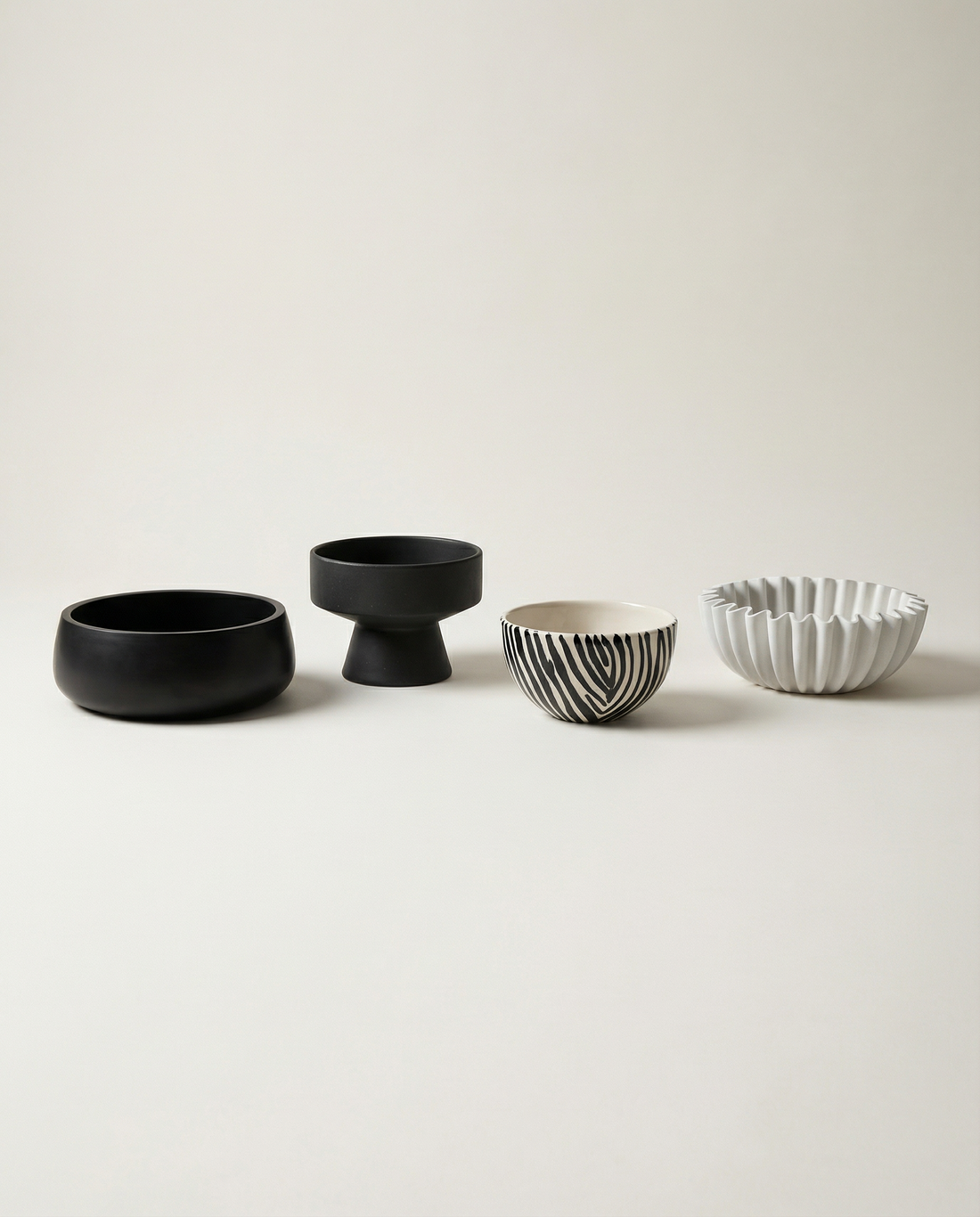 Minimalistische Kerzenschalen aus Keramik in Schwarz, Weiss und Muster, ruhig und harmonisch gruppiert dargestellt